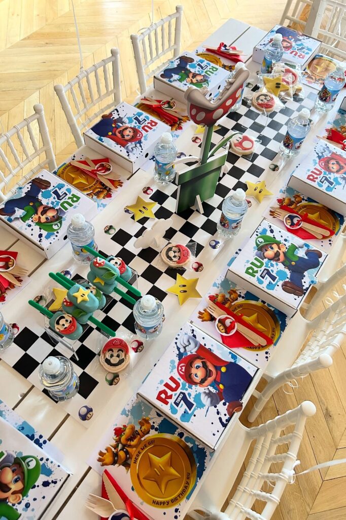 Mario-themed birthday party table with books, water bottles, and decorations for a Super Mario celeb.