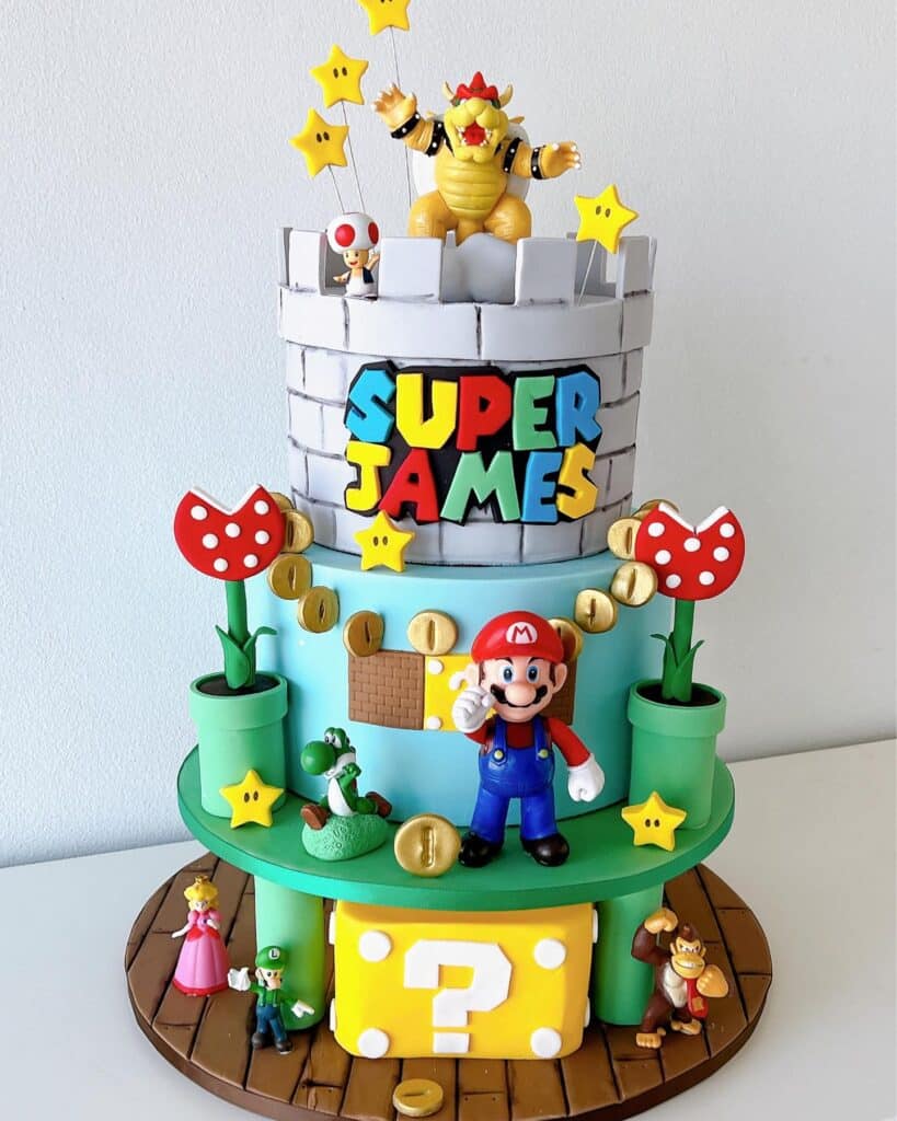 Colorful Super Mario-themed birthday cake with Mario, Bowser, and stars, perfect for kids' parties.
