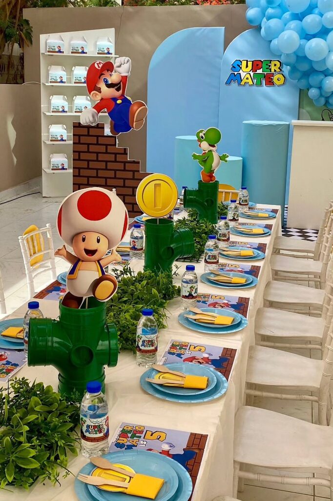 A colorful Super Mario-themed birthday party setup with character decorations and themed tableware.