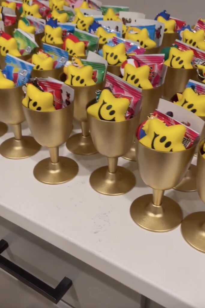Yellow Super Mario-themed party favor cups filled with candy and toys, perfect for a birthday celebr.