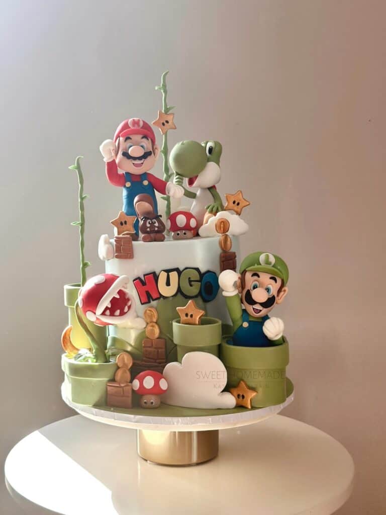 A colorful Super Mario-themed birthday cake with Mario, Luigi, Yoshi, and themed decorations.