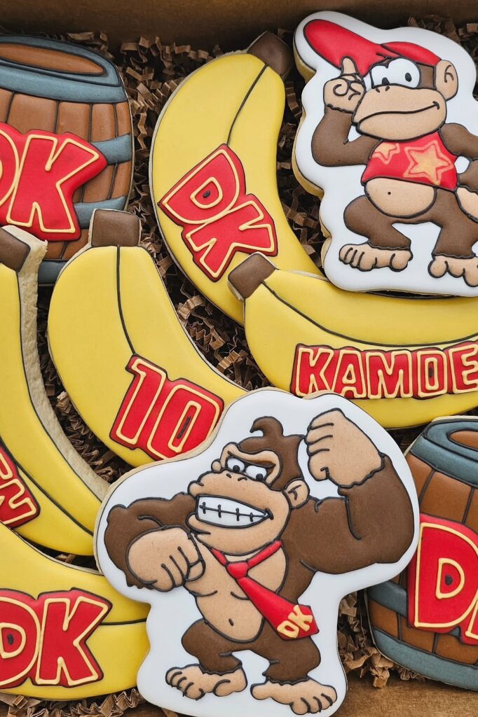 A colorful assortment of Donkey Kong-themed cookies with bananas, barrels, and character images for.