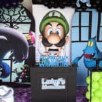 Luigi's Mansion themed birthday party decoration with balloons and character cutouts.