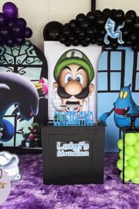 Luigi's Mansion themed birthday party decoration with balloons and character cutouts.
