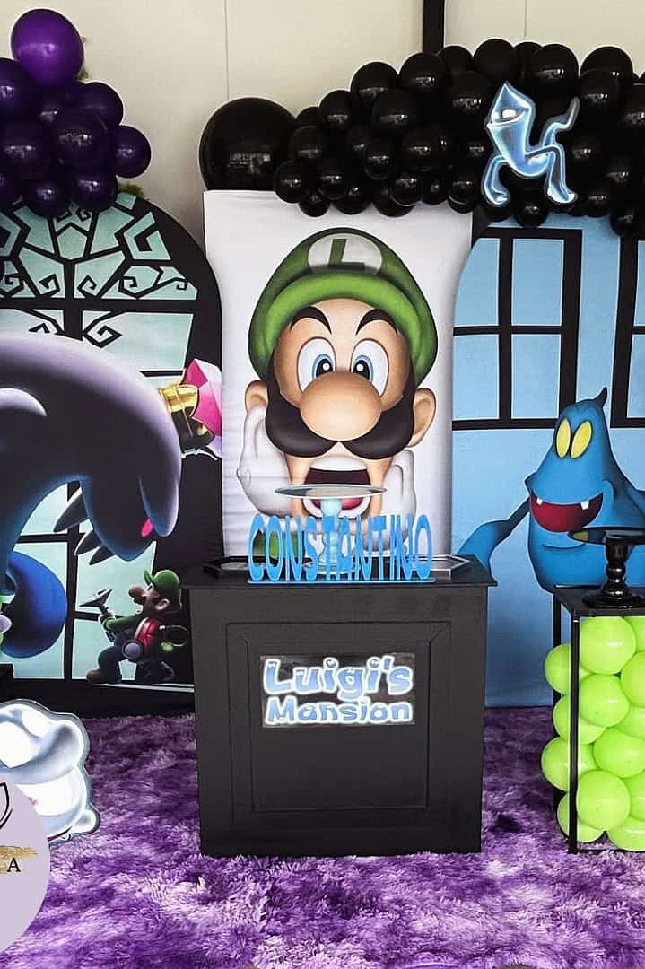 Luigi's Mansion themed birthday party decoration with balloons and character cutouts.