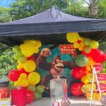 A colorful Donkey Kong-themed birthday party setup with balloons, banners, and decorations.