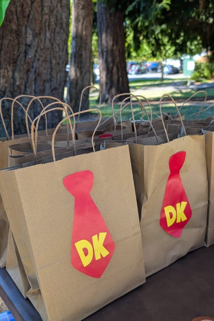 A colorful DK-themed paper gift bag for a Donkey Kong birthday party.