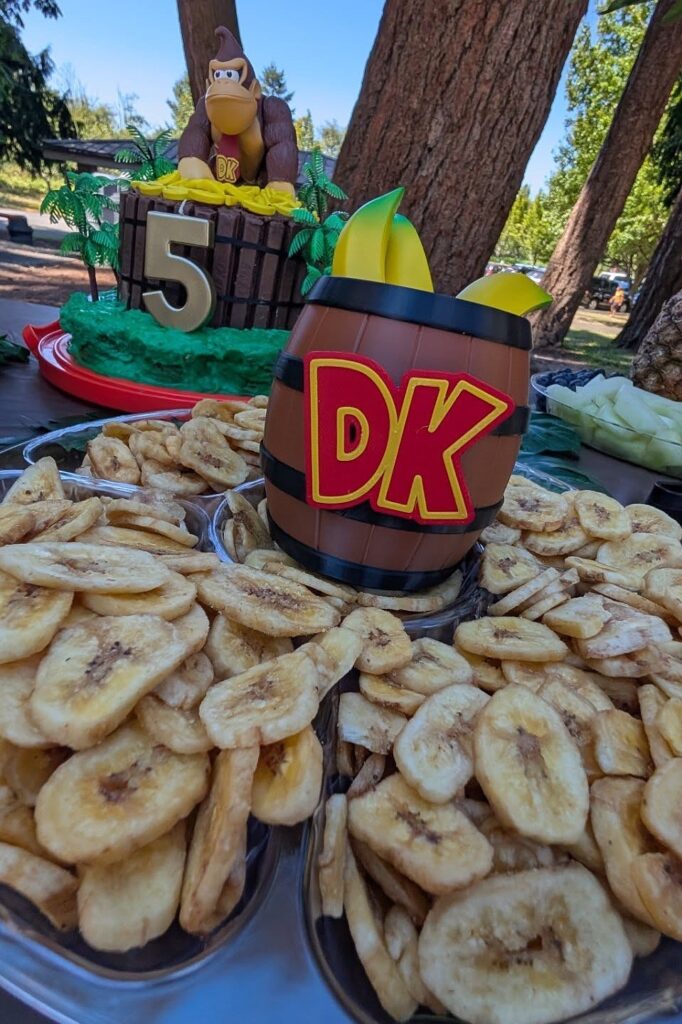 A colorful Donkey Kong-themed birthday party setup with banana snacks and themed decorations.