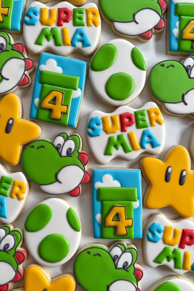 Yoshi-themed birthday cookies with colorful decorations for a Super Mario party celebration.