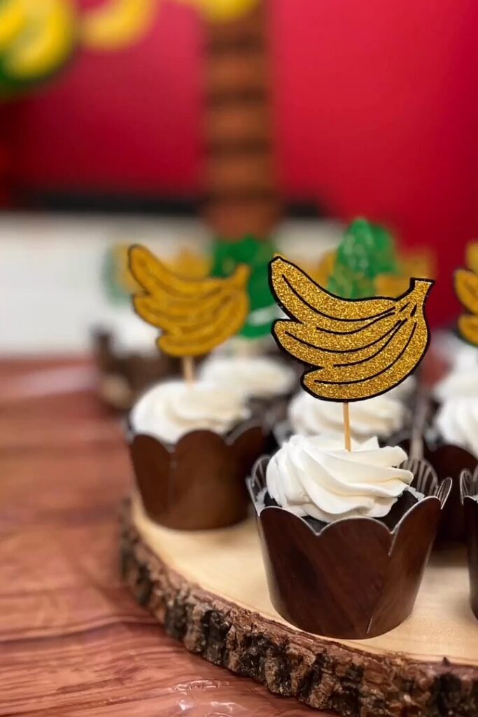 A colorful Donkey Kong-themed cupcake with banana toppers for a birthday party.