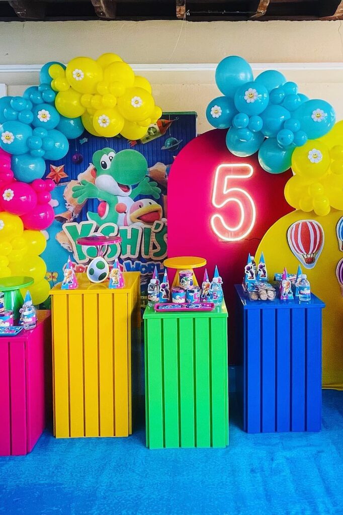 Colorful Yoshi-themed birthday party decorations with balloons and party favors for kids.