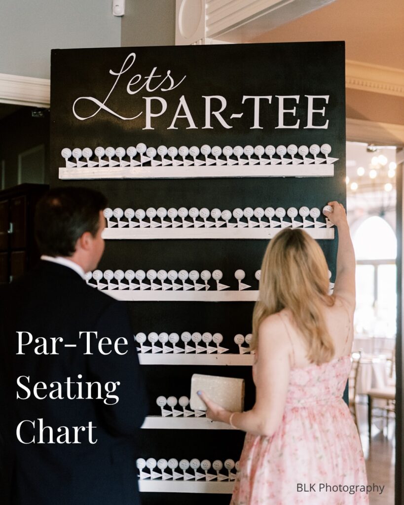 A colorful wedding seating chart with white golf tee markers on a blackboard background.
