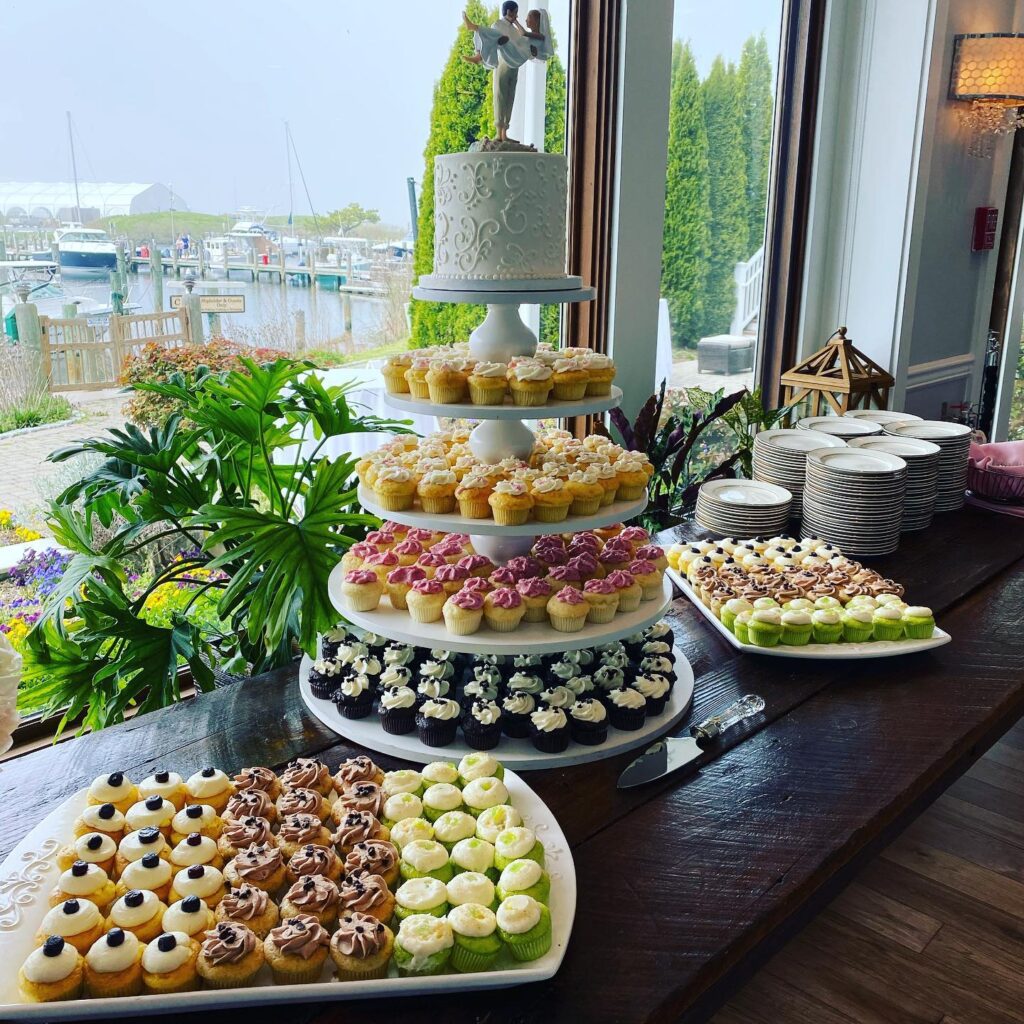 Elegant wedding cupcake display with a tiered stand and floral decorations at Confetti & Roses.