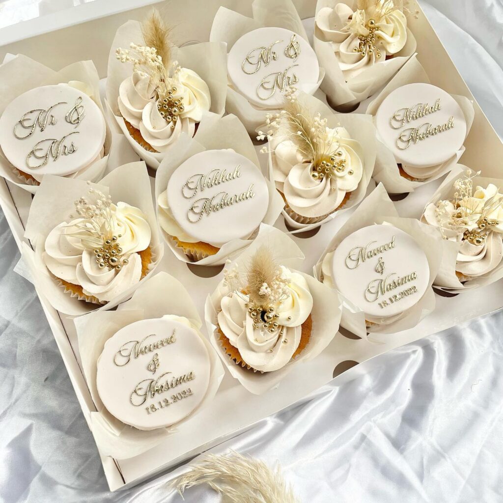 Elegant wedding cupcakes with white fondant and gold accents for a wedding celebration.