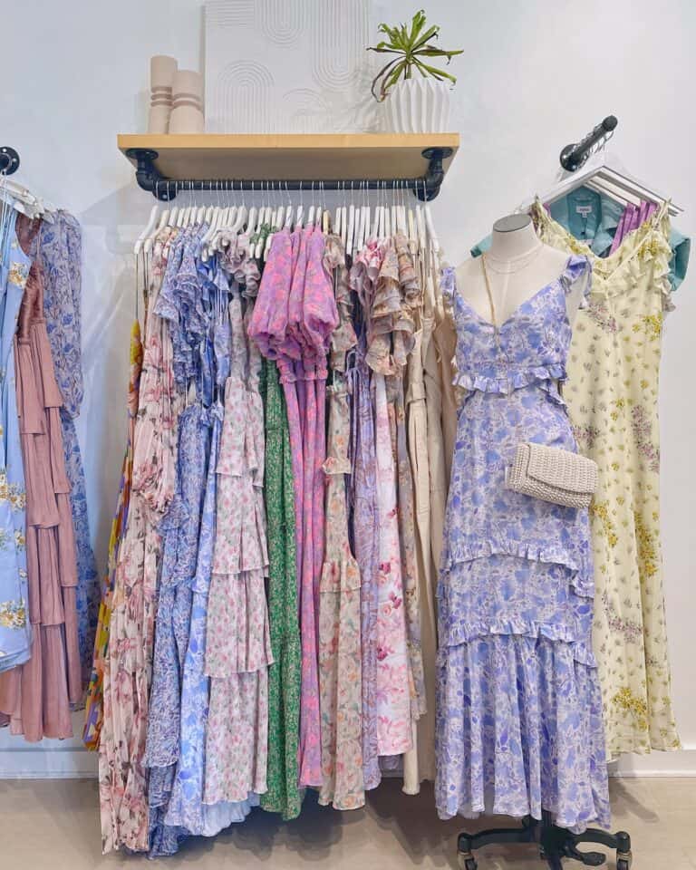 Floral maxi dresses and sundresses displayed on a clothing rack at Confetti & Roses boutique.