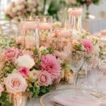Elegant wedding table centerpiece with floating candles and pink roses.