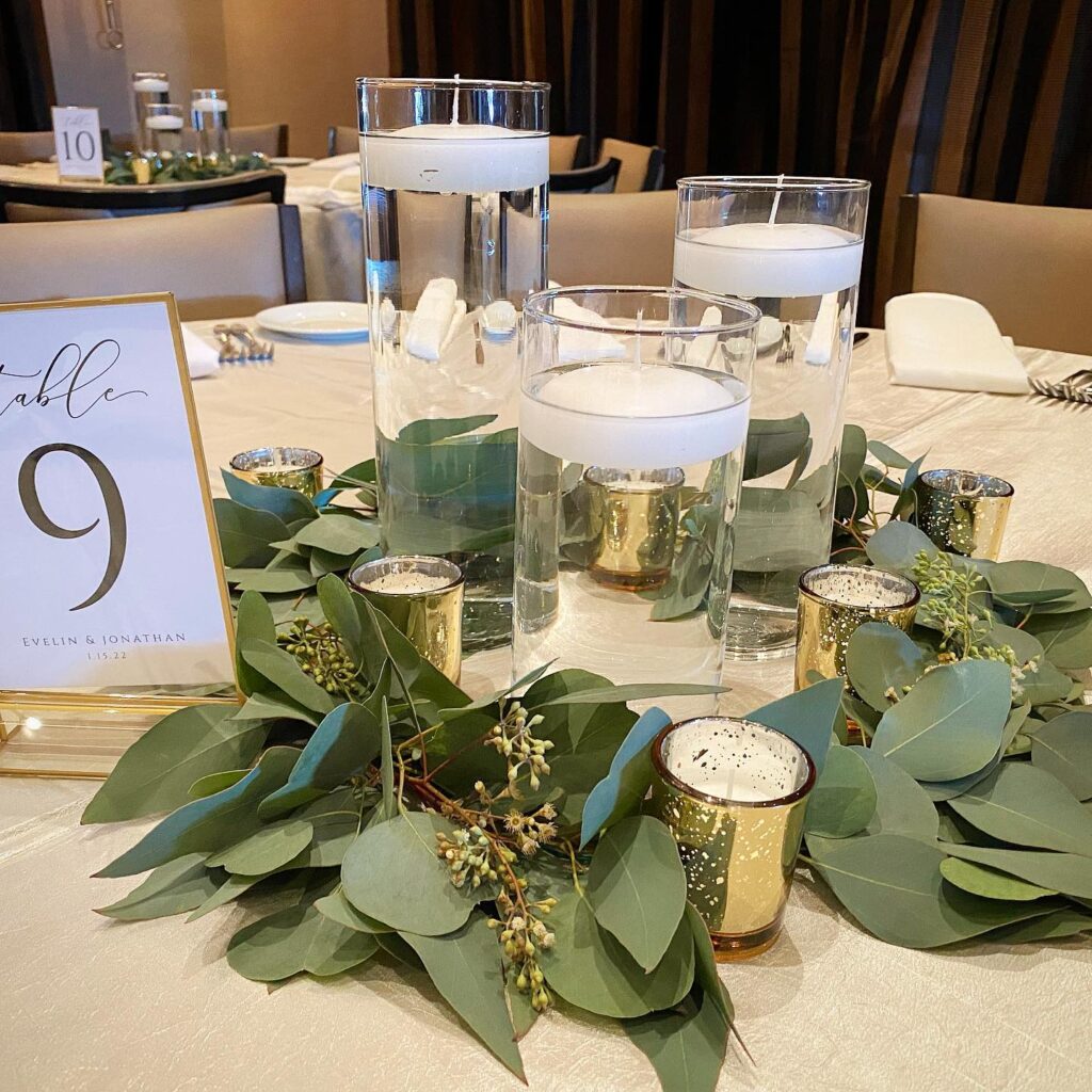 Elegant wedding centerpiece with floating candles and greenery for reception decor.