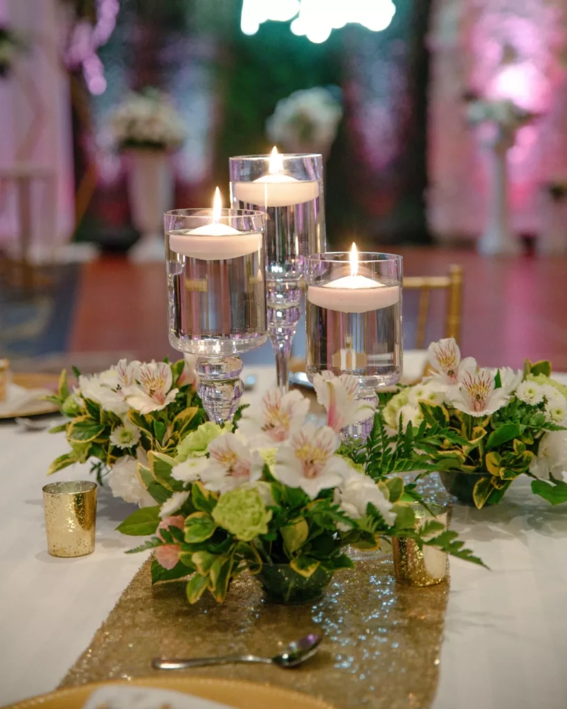 Elegant floating candles with floral centerpiece for wedding reception decor.