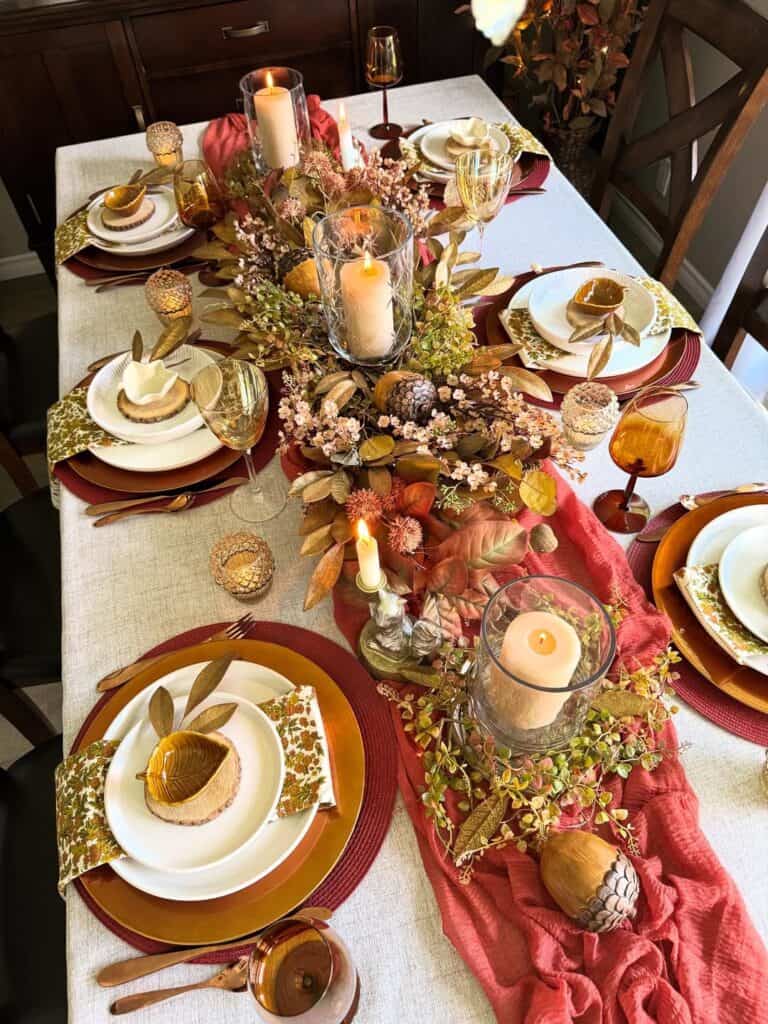 Elegant Thanksgiving tablescape with candles, floral arrangements, and vintage-inspired tableware.
