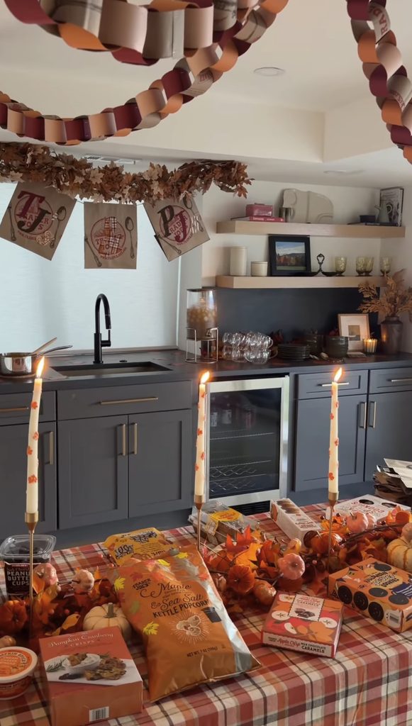 Friendsgiving celebration with decorated table, candles, and festive decor in kitchen.