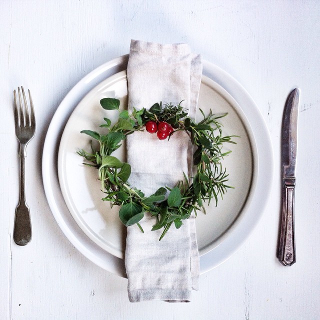 Elegant holiday table setting with a wreath, napkin, and vintage cutlery for Christmas.