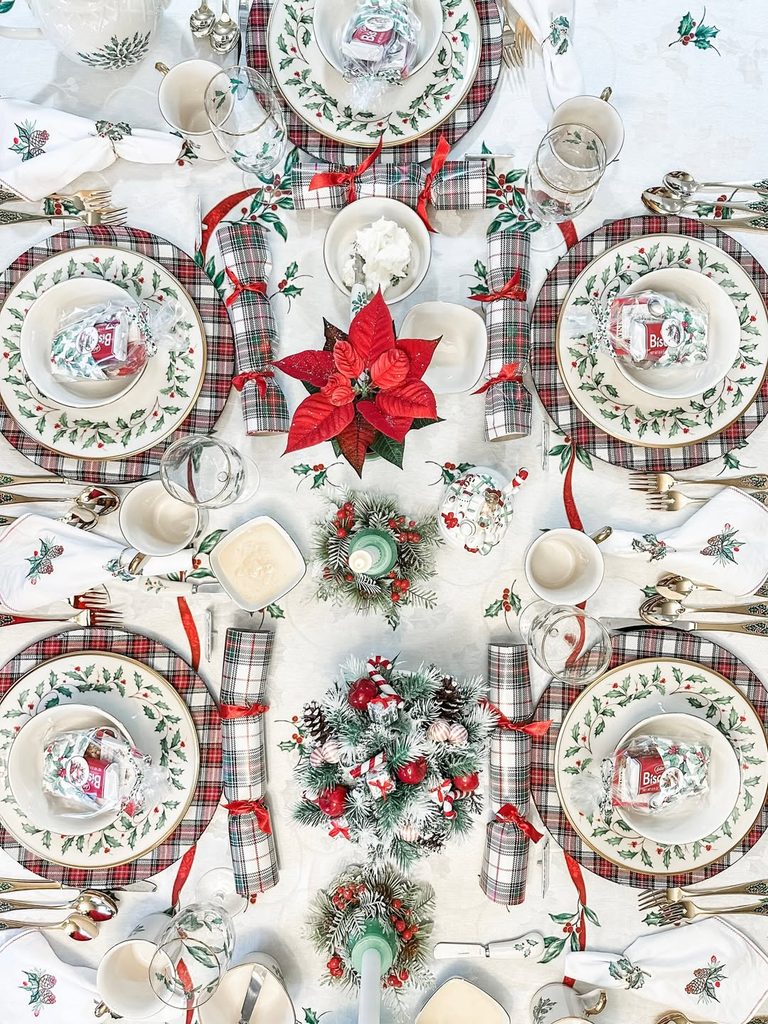 Festive Christmas luncheon table setting with poinsettia centerpiece and holiday decor.