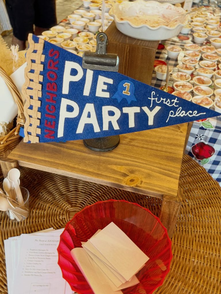 Pie contest winner pennant at Friendsgiving celebration with desserts and table setting.