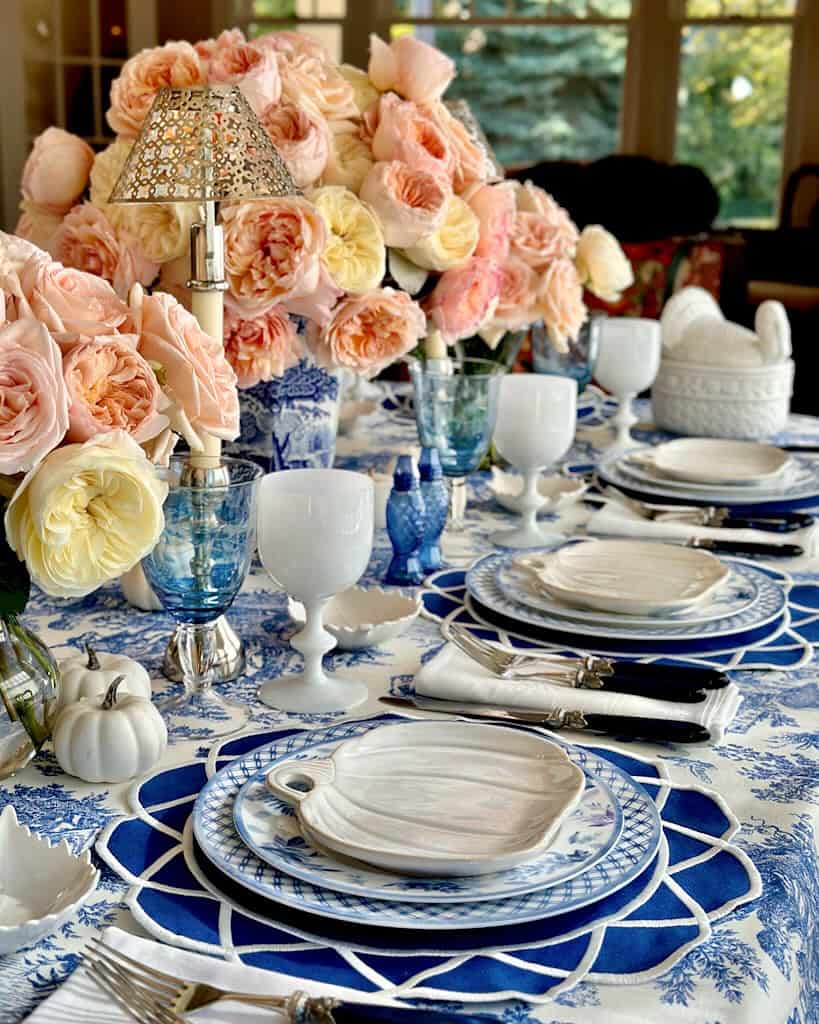 Elegant Thanksgiving table setting with blue and white china and floral centerpiece.