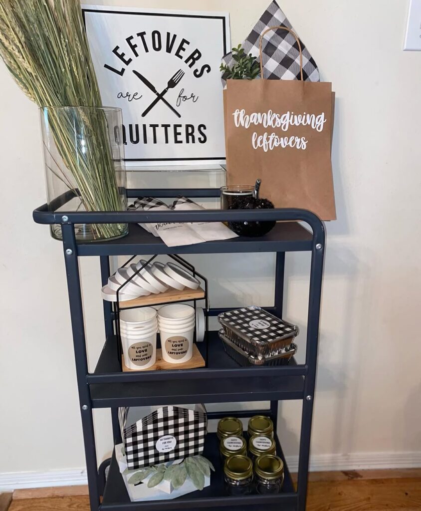 Thanksgiving leftovers display with jars, paper bags, and decorative signs on a black cart.