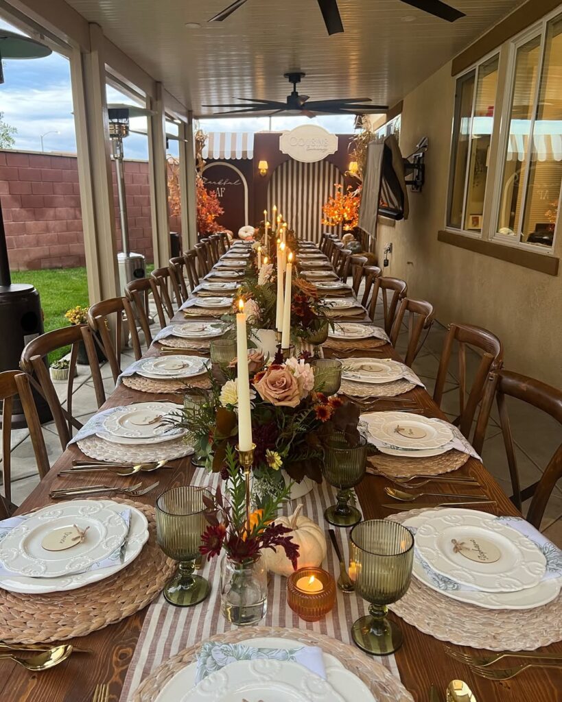 Elegant Thanksgiving dining table with candles, floral centerpieces, and fine china.