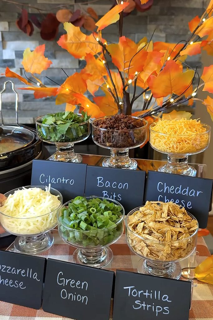 Colorful fall-themed snack display with cheese, green onion, and tortilla strips.