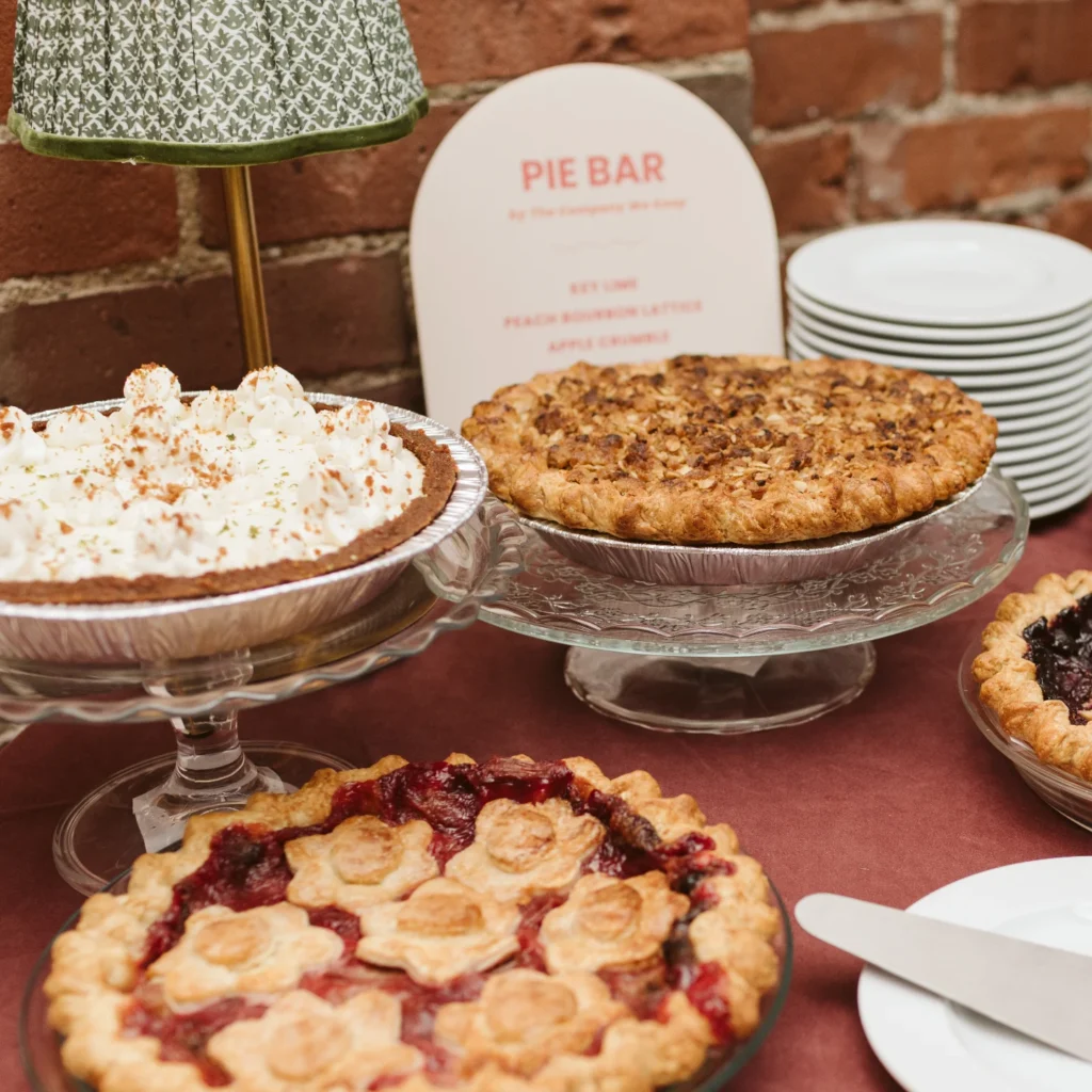 Assorted homemade pies on a dessert table for Thanksgiving celebration.