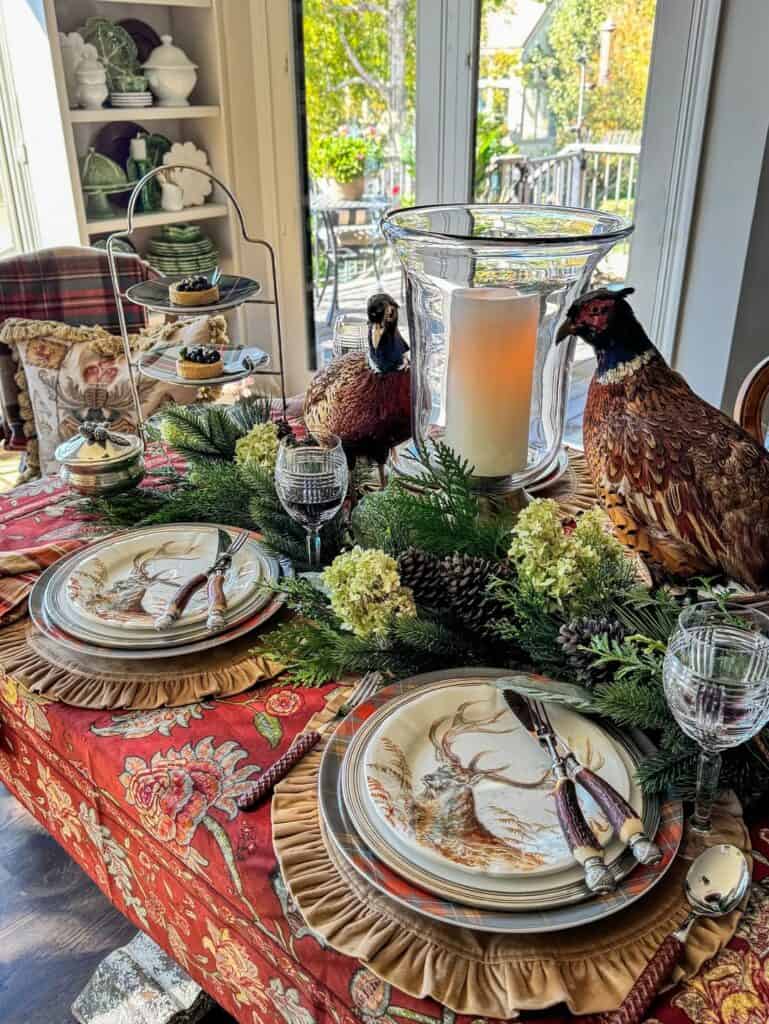 Vintage Thanksgiving tablescape with autumn decor, pheasant figurines, and elegant tableware.