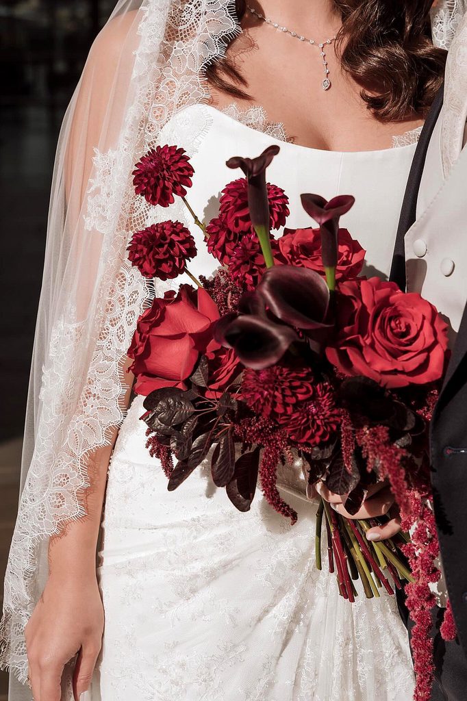 Elegant winter wedding bouquet with deep red roses and calla lilies.