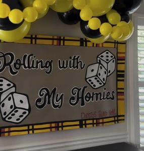 Bunco game night banner with yellow and black balloons for party decor.