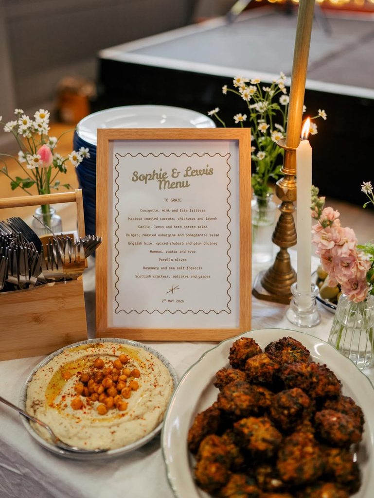Elegant wedding reception table with menu, candles, and food dishes for fall wedding.