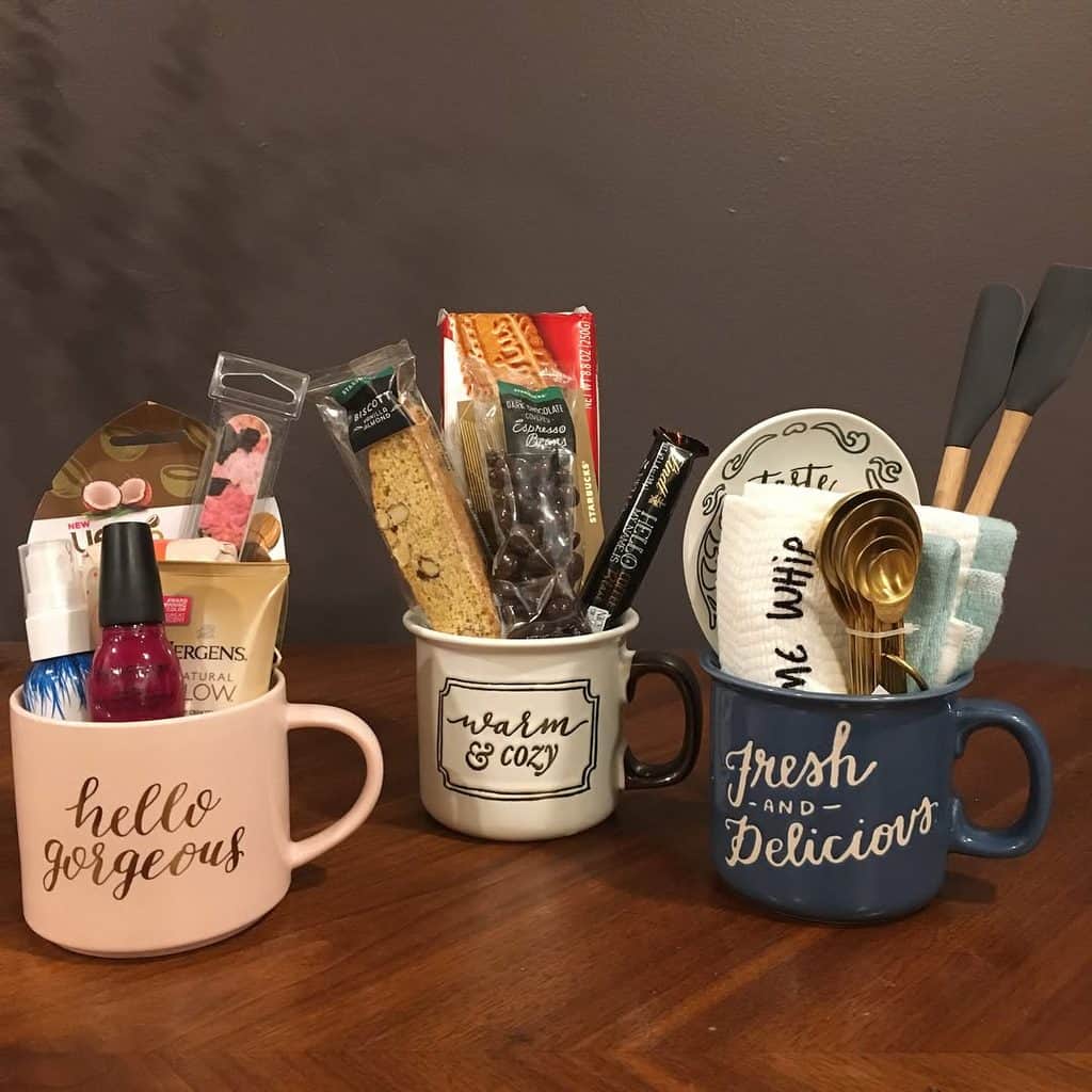 Assorted baking tools and ingredients in colorful mugs on a wooden table.