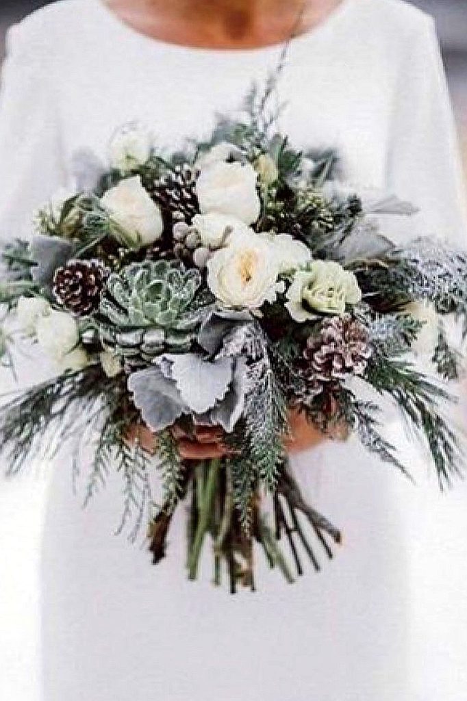 Elegant winter wedding bouquet with white roses, succulents, and greenery.