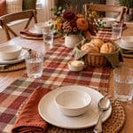 Cozy fall or winter dining table with floral centerpiece, bread basket, and place settings.